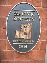 A sign on a brick wall that says the civic society design award 2016