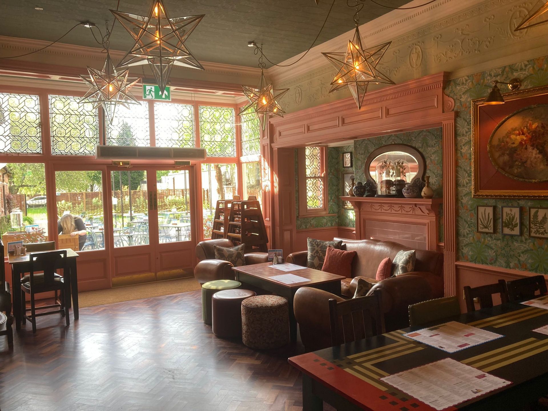 A large room with tables , chairs , a couch and a fireplace.