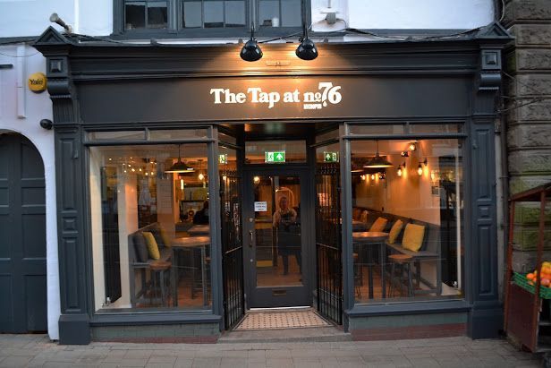 The front of a restaurant called the tap at no.76