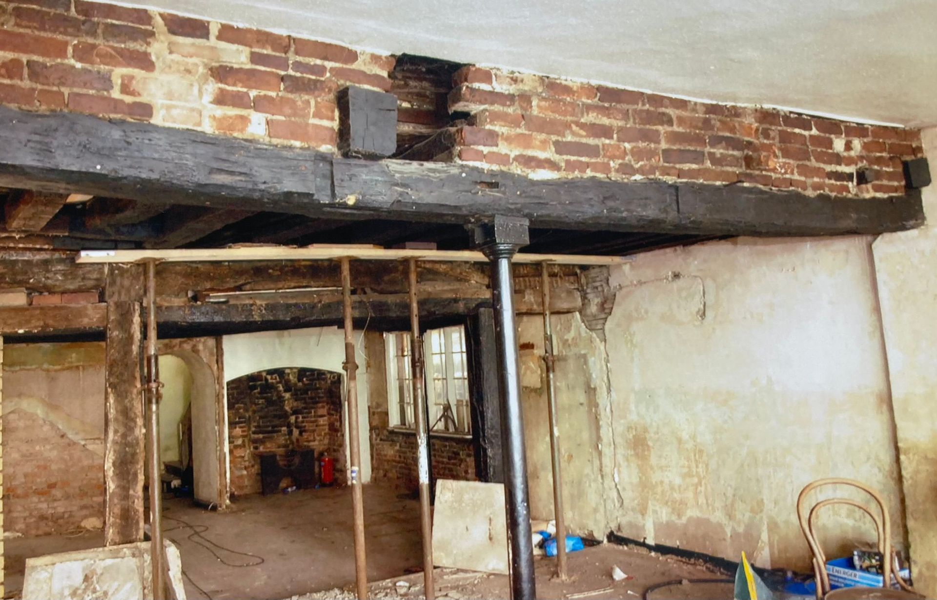 A room with a brick wall and wooden beams.