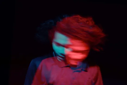 Green-tinted motion blur inside a tunnel, with bright light at the center