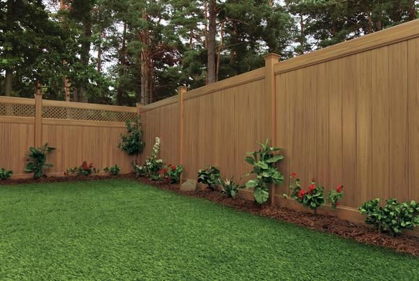 A wooden fence surrounds a lush green lawn in a backyard in Westerville