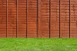 A wooden fence surrounds a lush green lawn in Columbus