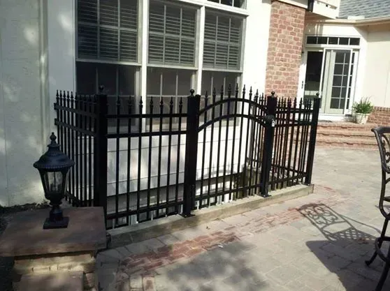 A black aluminum fence surrounds a patio area in front of a house in Columbus