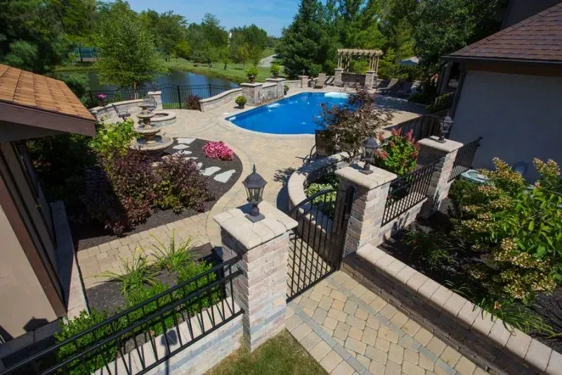 An aerial view of a house with a large swimming pool in the backyard and aluminum fence in Columbus