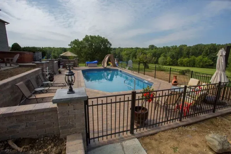 A large swimming pool is surrounded by an aluminum fence in Grove City