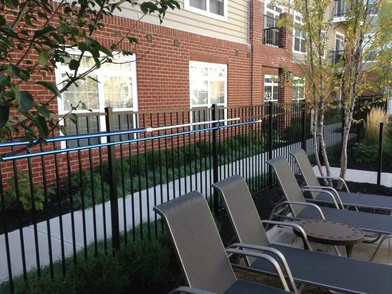 A row of lounge chairs in front of a black aluminum fence in Columbus