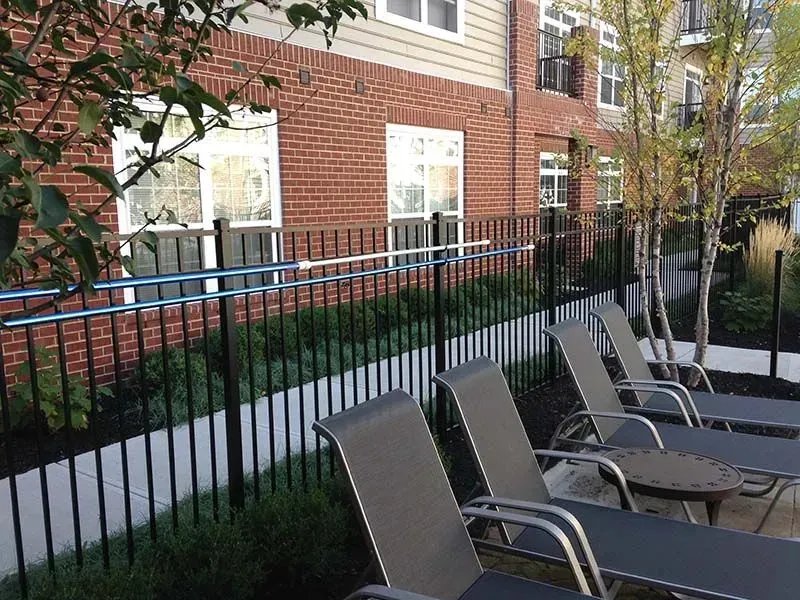 A row of lounge chairs are lined up in front of black aluminum fence in Columbus