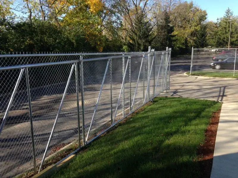 A chain link fence surrounds a lush green field in Columbus