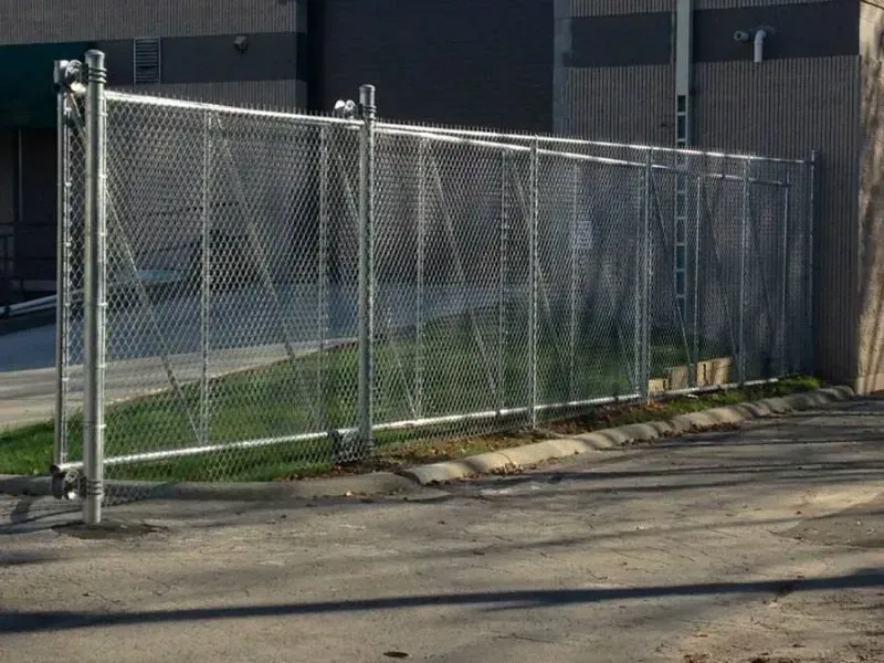 A chain link fence is surrounding a parking lot in front of a building in Columbus
