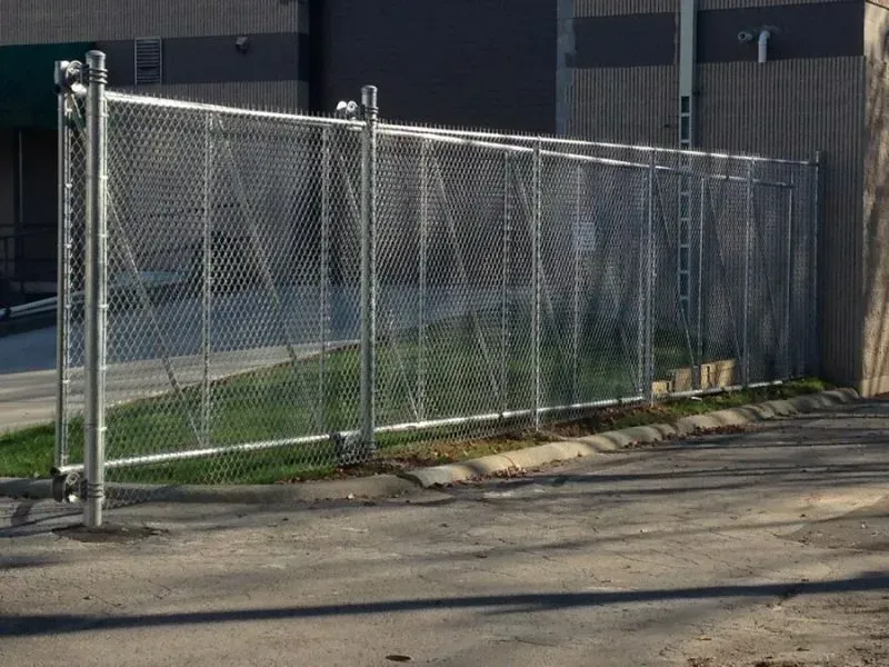 A chain link fence is surrounding a parking lot in front of a building in Columbus