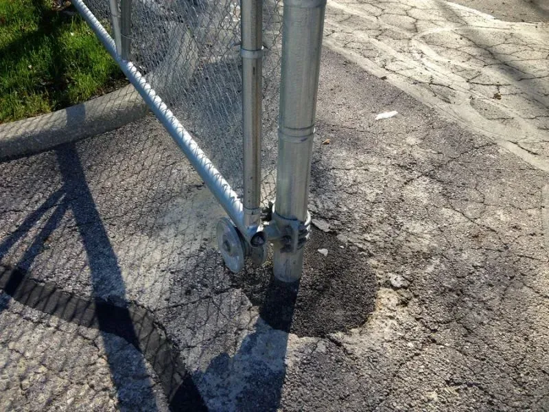 A chain link fence is sitting on the side of a road in Columbus