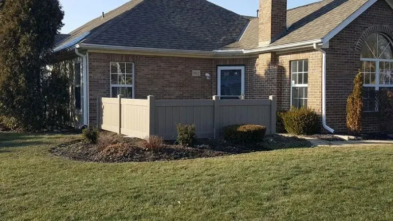 A brick house with a composite fence in front of it in Columbus