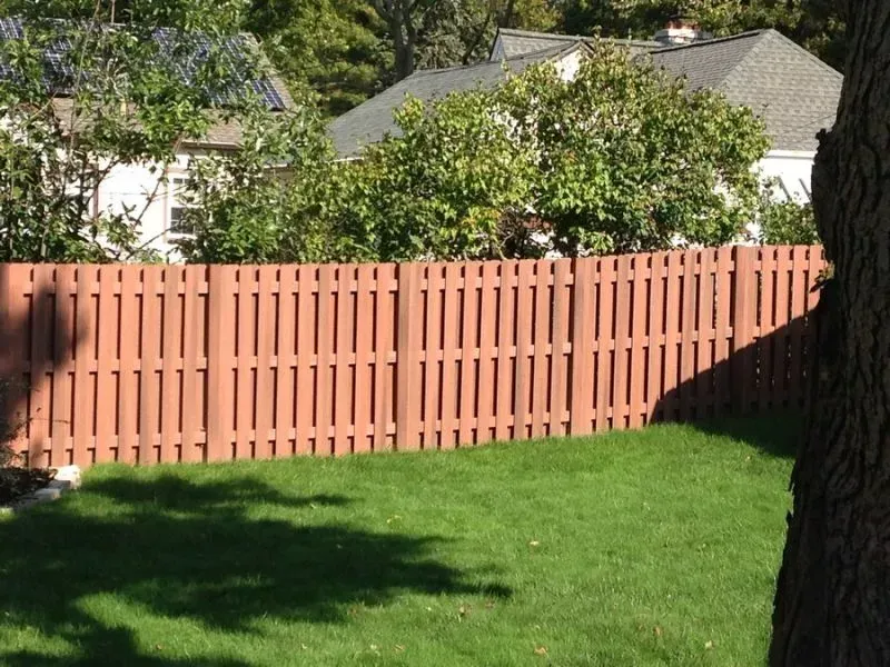 A wooden fence surrounds a grassy field in front of a house in Dublin