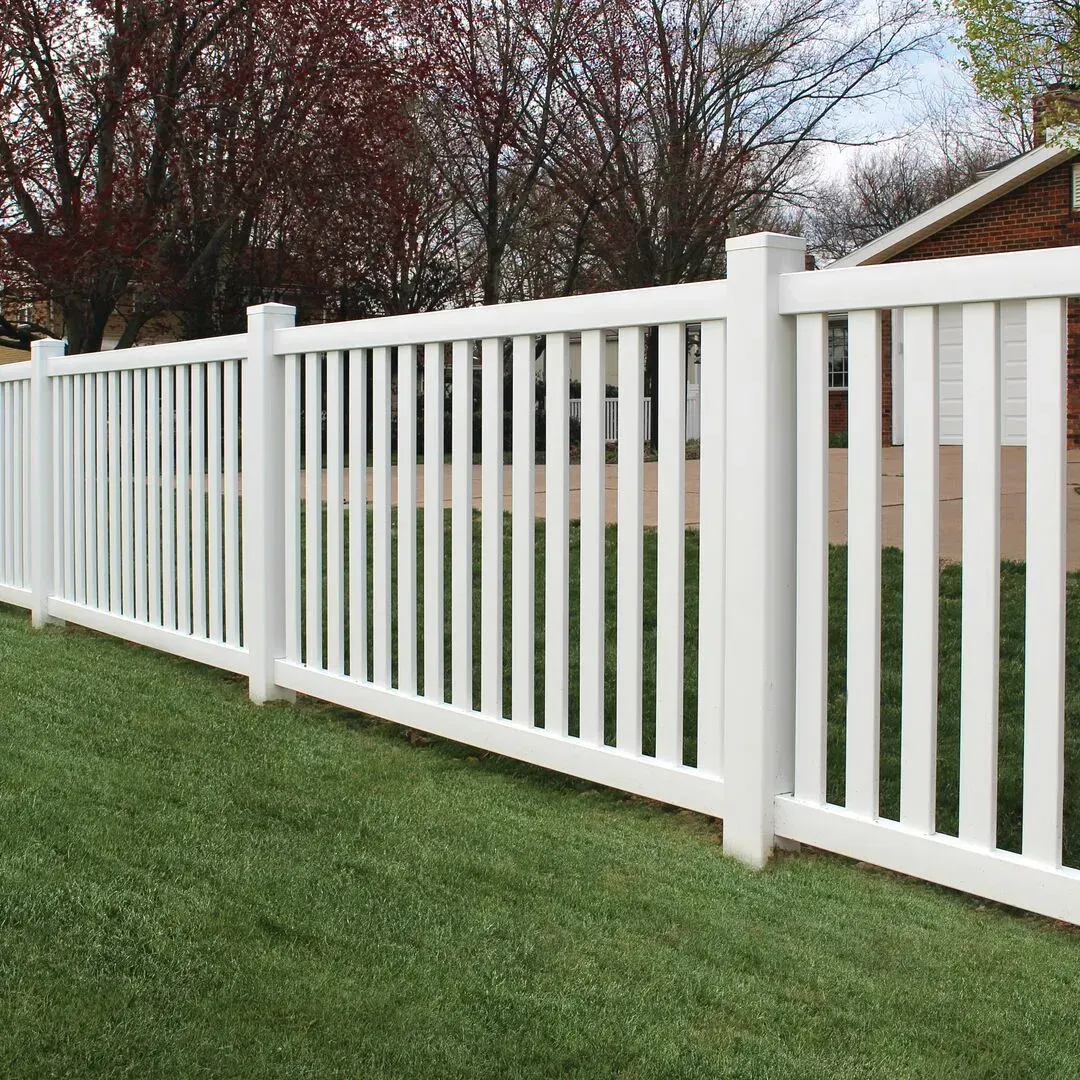 A white vinyl fence is sitting on top of a lush green lawn in Columbus