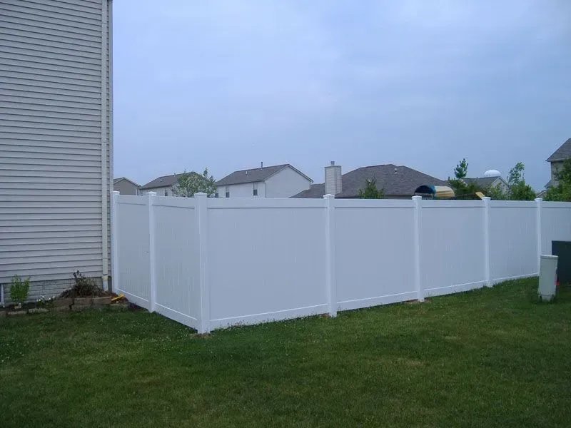 A white vinyl fence is in the backyard of a house in Columbus