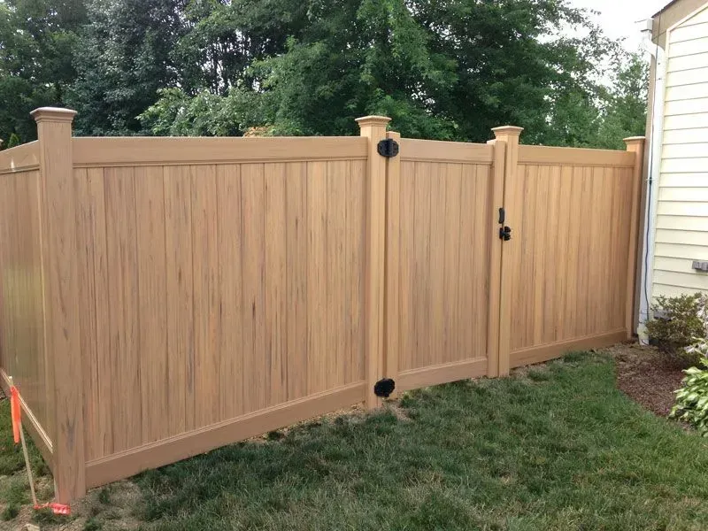 A vinyl fence with a gate in the backyard of a house in Columbus
