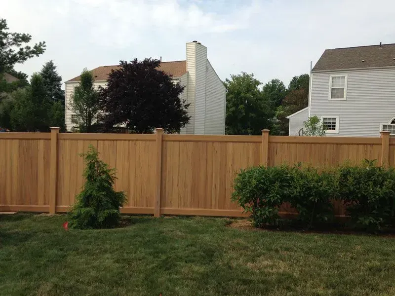 A vinyl fence with a house in the background in Columbus