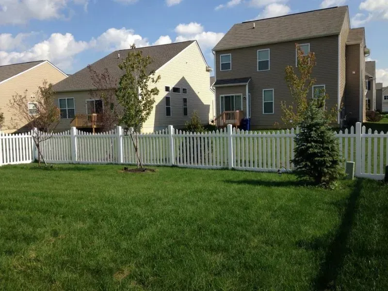 A white picket fence surrounds a lush green yard in Galena
