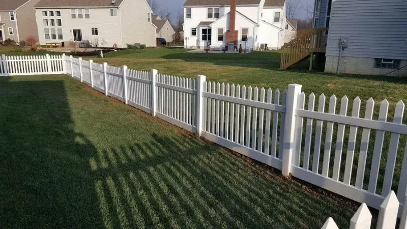 A white picket vinyl fence surrounds a lush green yard in Columbus
