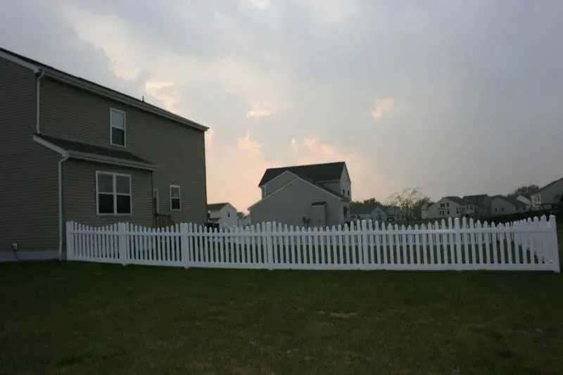 A house with a white picket vinyl fence in front of it in Columbus