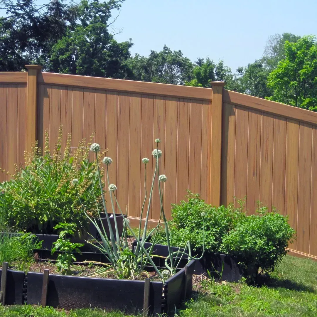 A wooden vinyl fence with a garden in front of it in Columbus
