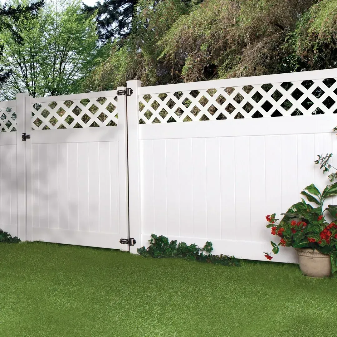 A white vinyl fence with a lattice design is sitting on top of a lush green lawn in Hillard
