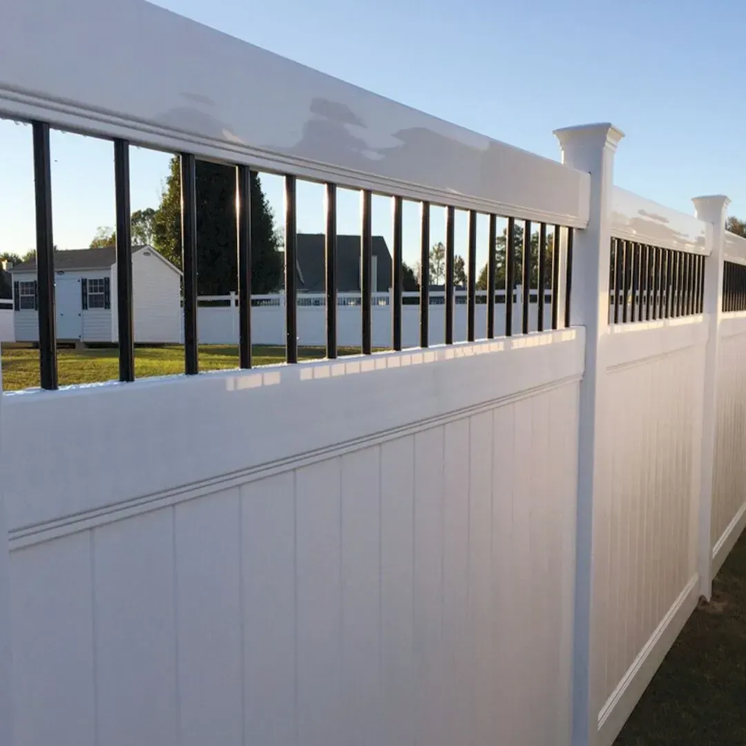 A white vinyl fence with black bars and a house in the background in Columbus