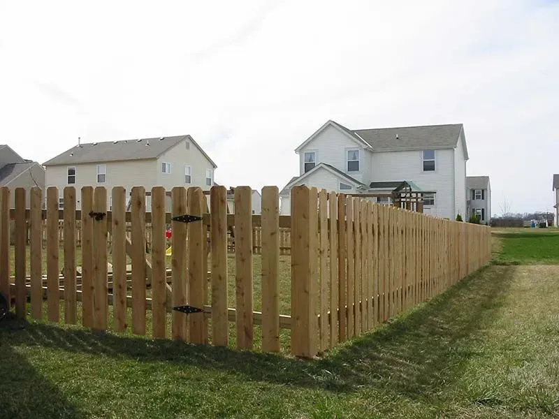 A wooden fence surrounds a grassy field in front of a house in Upper Arlington