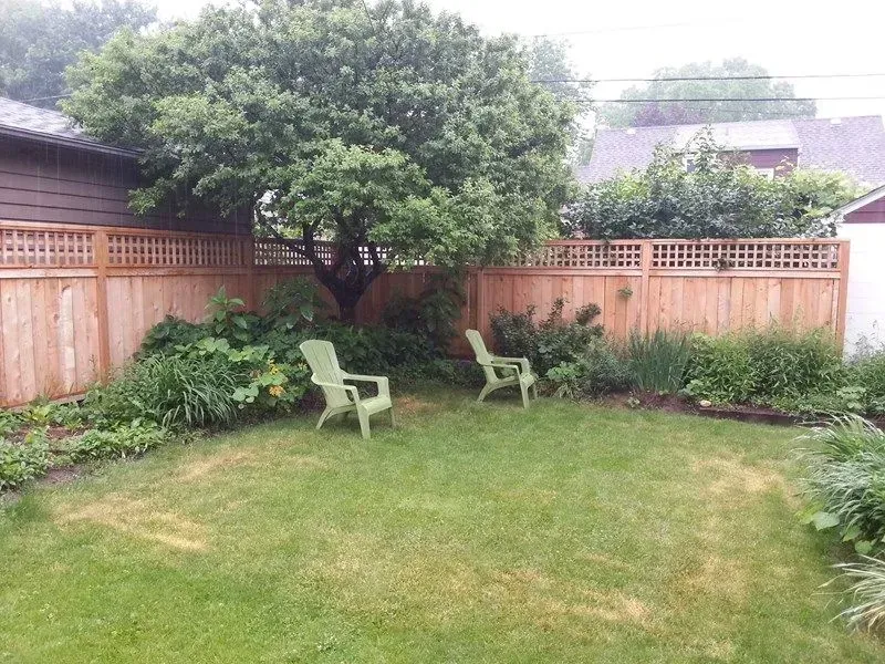 A backyard with a wooden fence and two chairs in Columbus