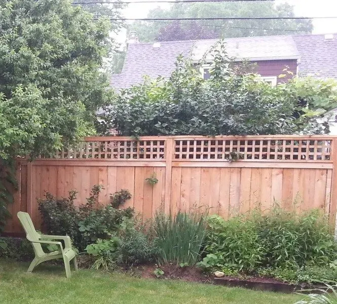 A wooden fence with a green chair in front of it in Columbus