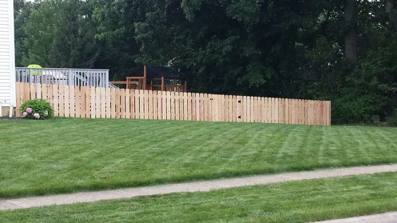 A wooden fence surrounds a lush green lawn in Columbus