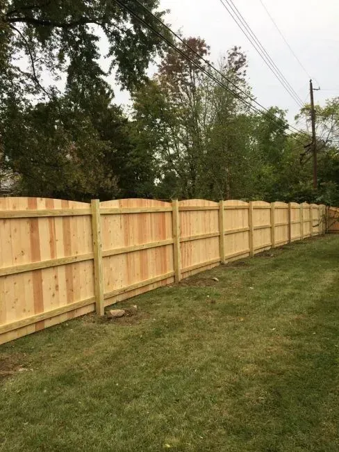 A wooden fence is sitting in the middle of a lush green field in Columbus