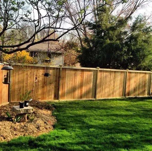 A wooden fence surrounds a lush green yard in Columbus