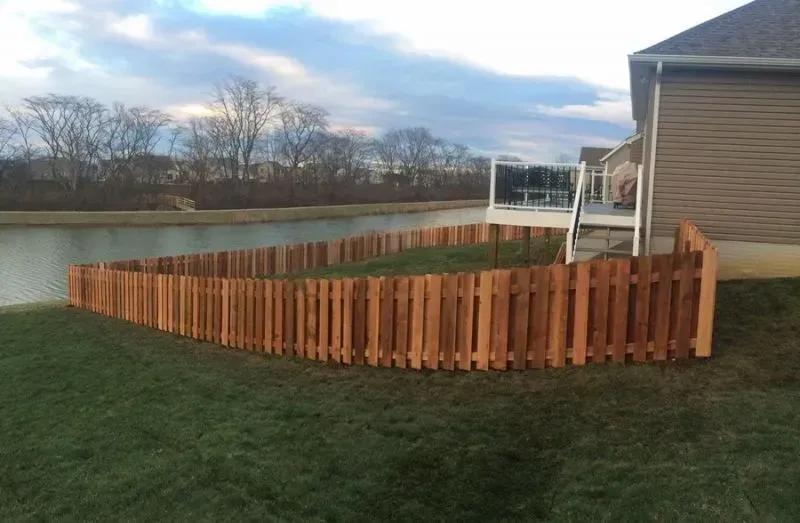 A wooden fence surrounds a house next to a lake in Columbus