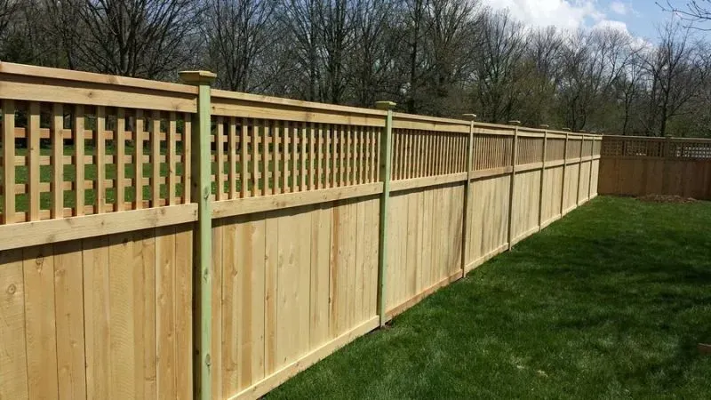 A wooden fence is sitting on top of a lush green lawn in Columbus