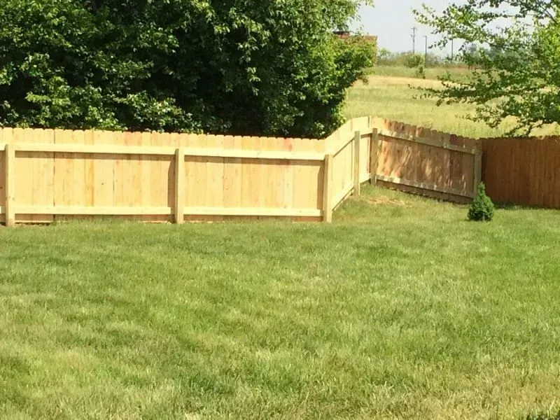 A wooden fence surrounds a lush green yard in Columbus