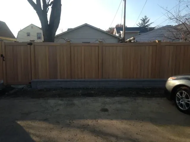 A car is parked in front of a wooden fence in Columbus