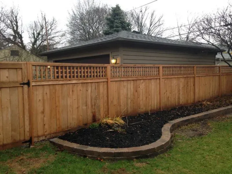 A wooden fence surrounds a small garage in a backyard in Columbus