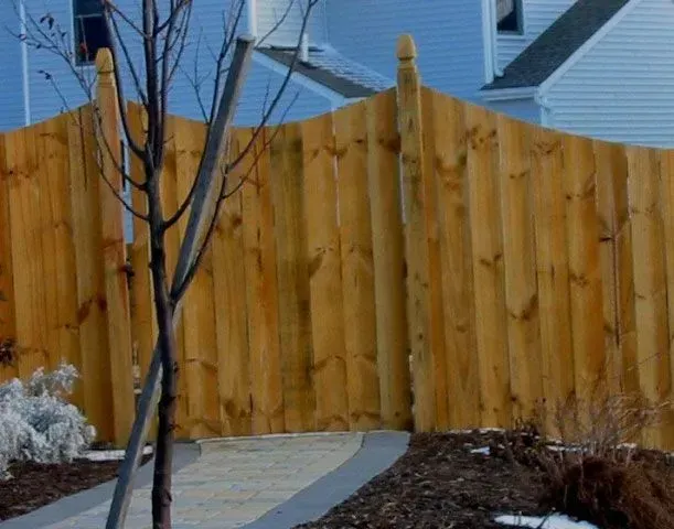 A wooden fence with a tree in front of it in Columbus