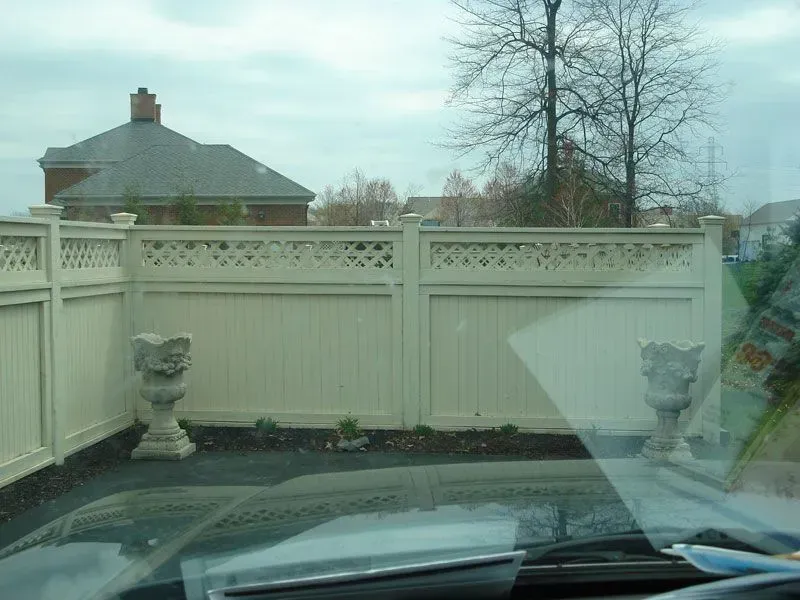 A white wood fence is visible through the windshield of a car in Columbus