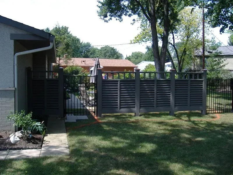 A backyard with a wood fence and a house in the background in Columbus