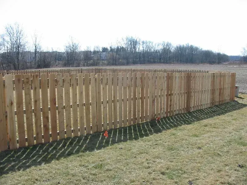 A wooden fence is sitting in the middle of a grassy field in Columbus