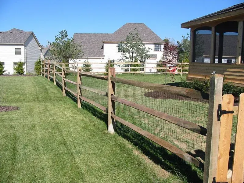 A wooden fence surrounds a lush green yard in Columbus