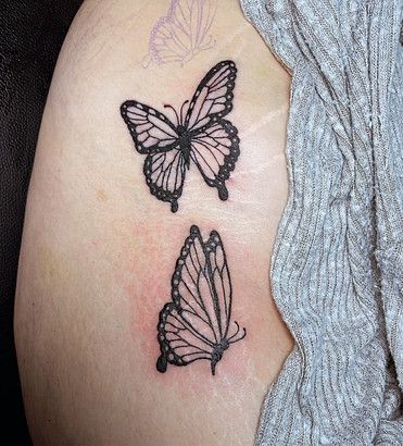 A woman has three butterflies tattooed on her shoulder.