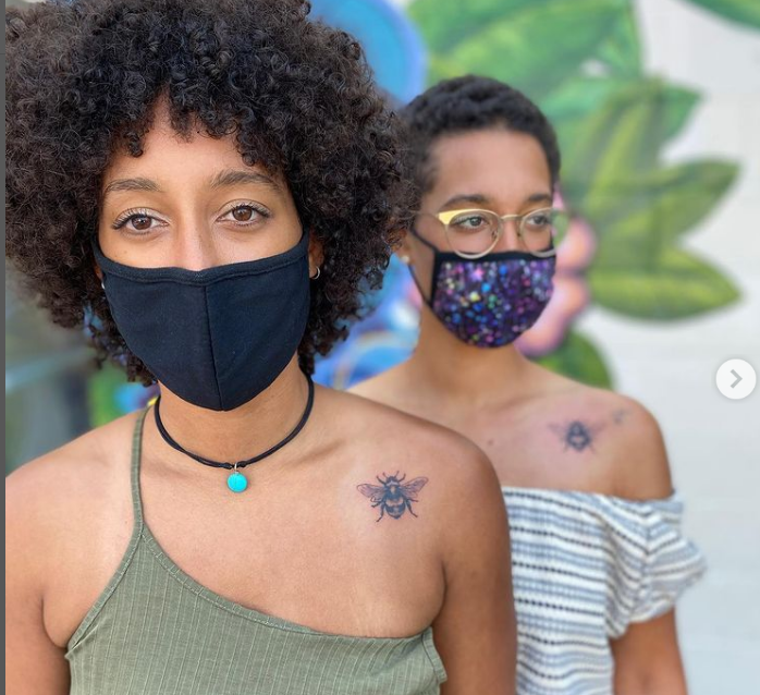 Two women wearing face masks are standing next to each other