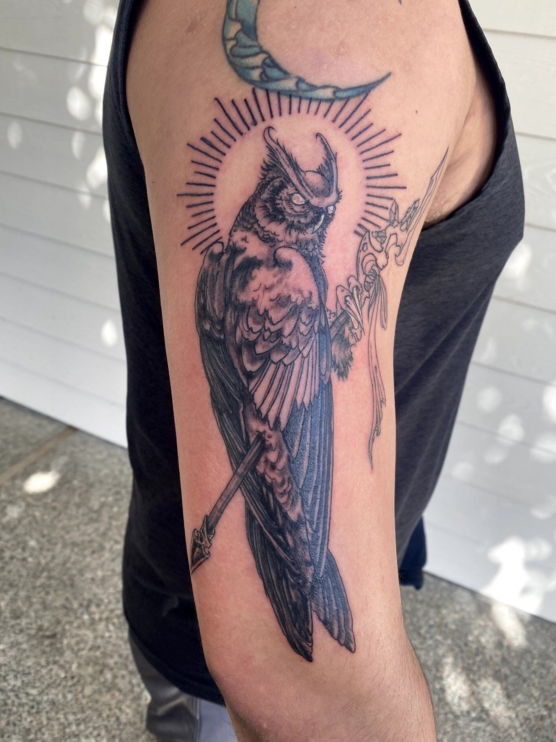 A man has a tattoo of an owl on his arm