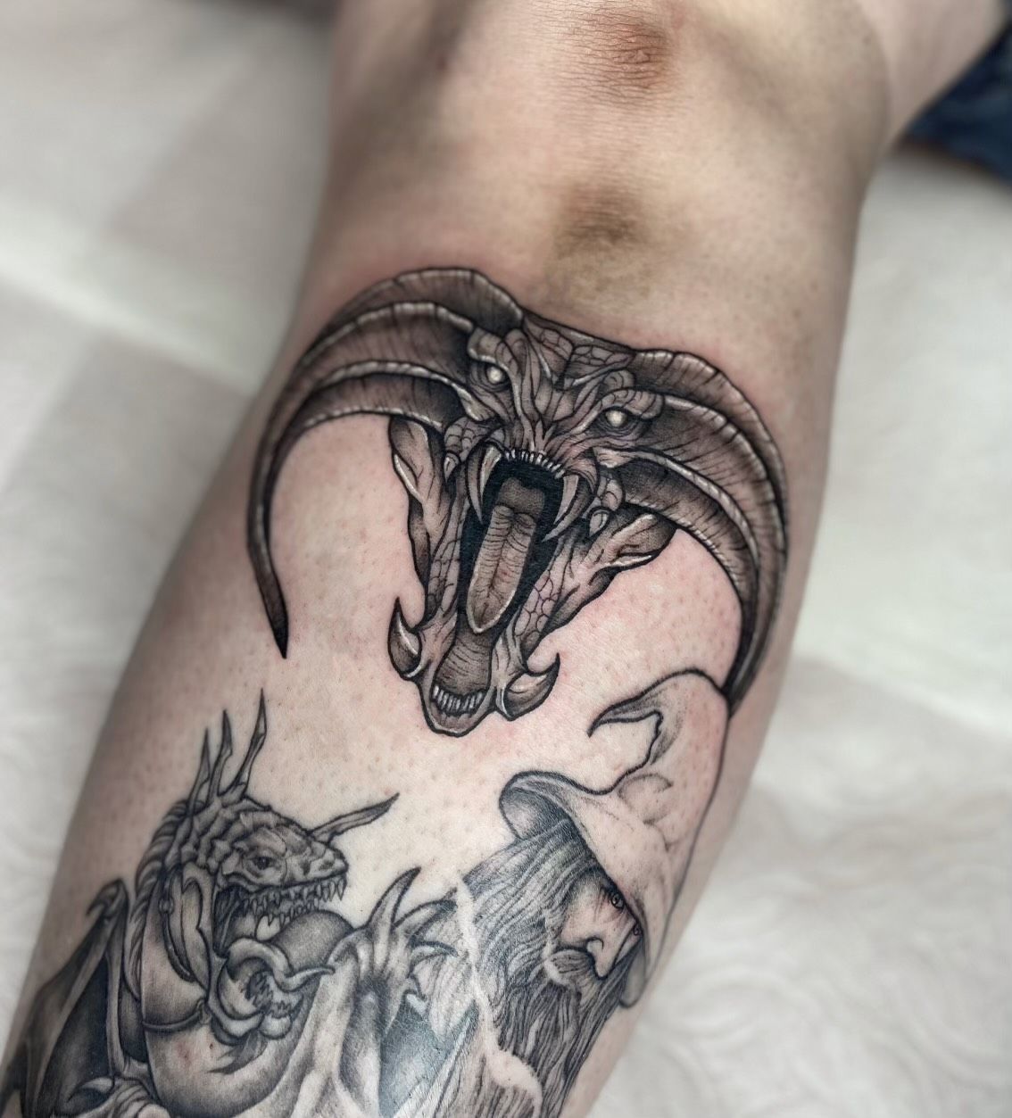 A person has a tattoo of a dragon on their arm