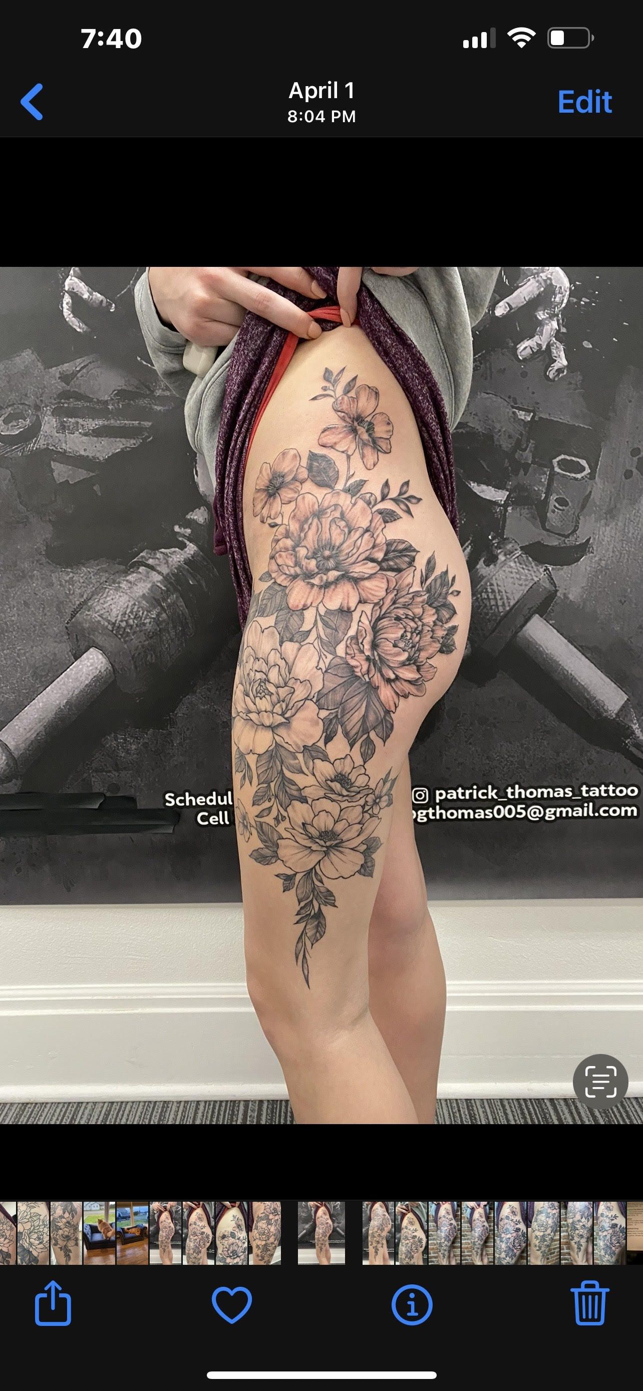 A woman is taking a picture of her tattoo on her leg.