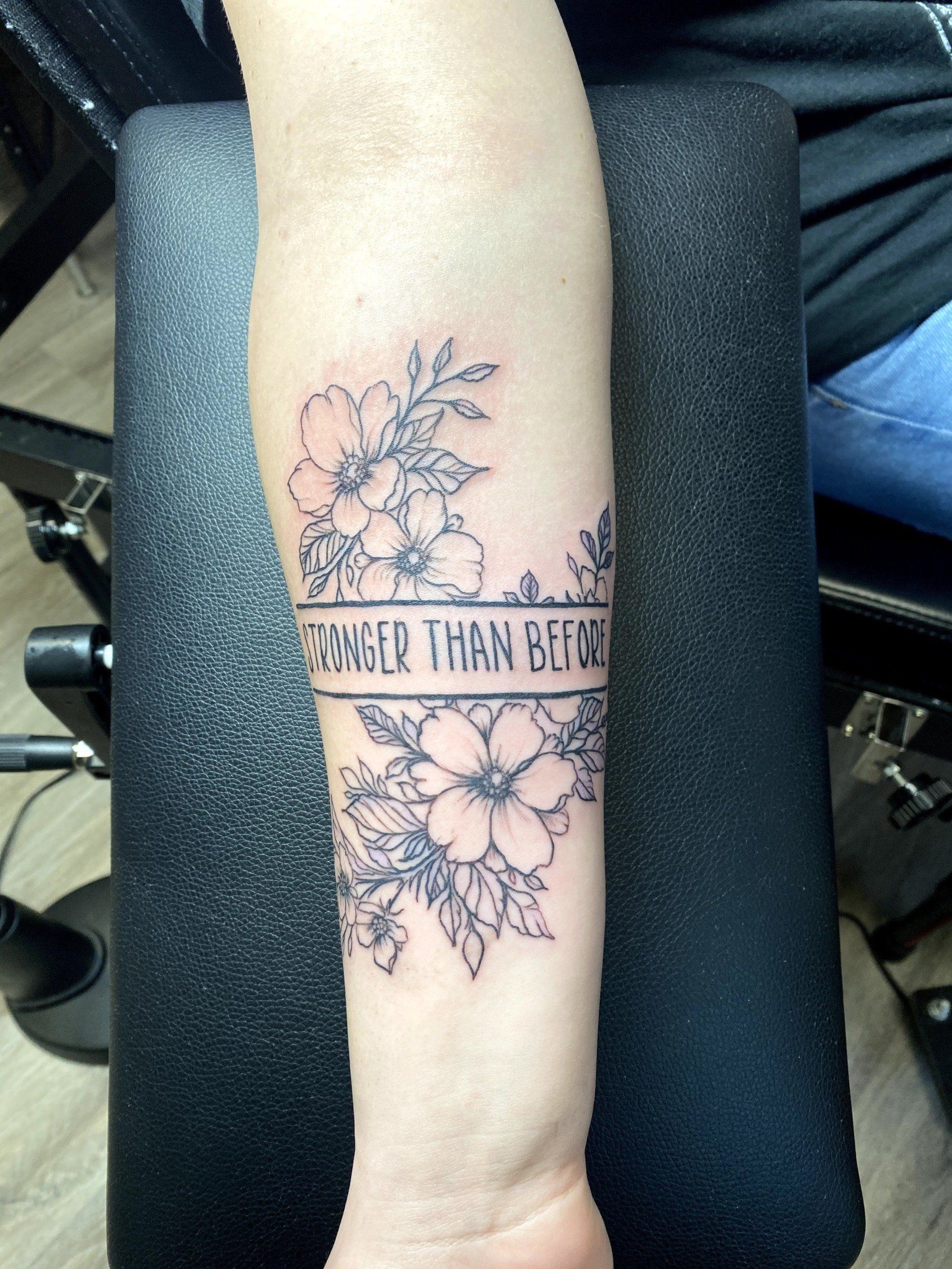 A tattoo on a person 's arm that says stronger than before